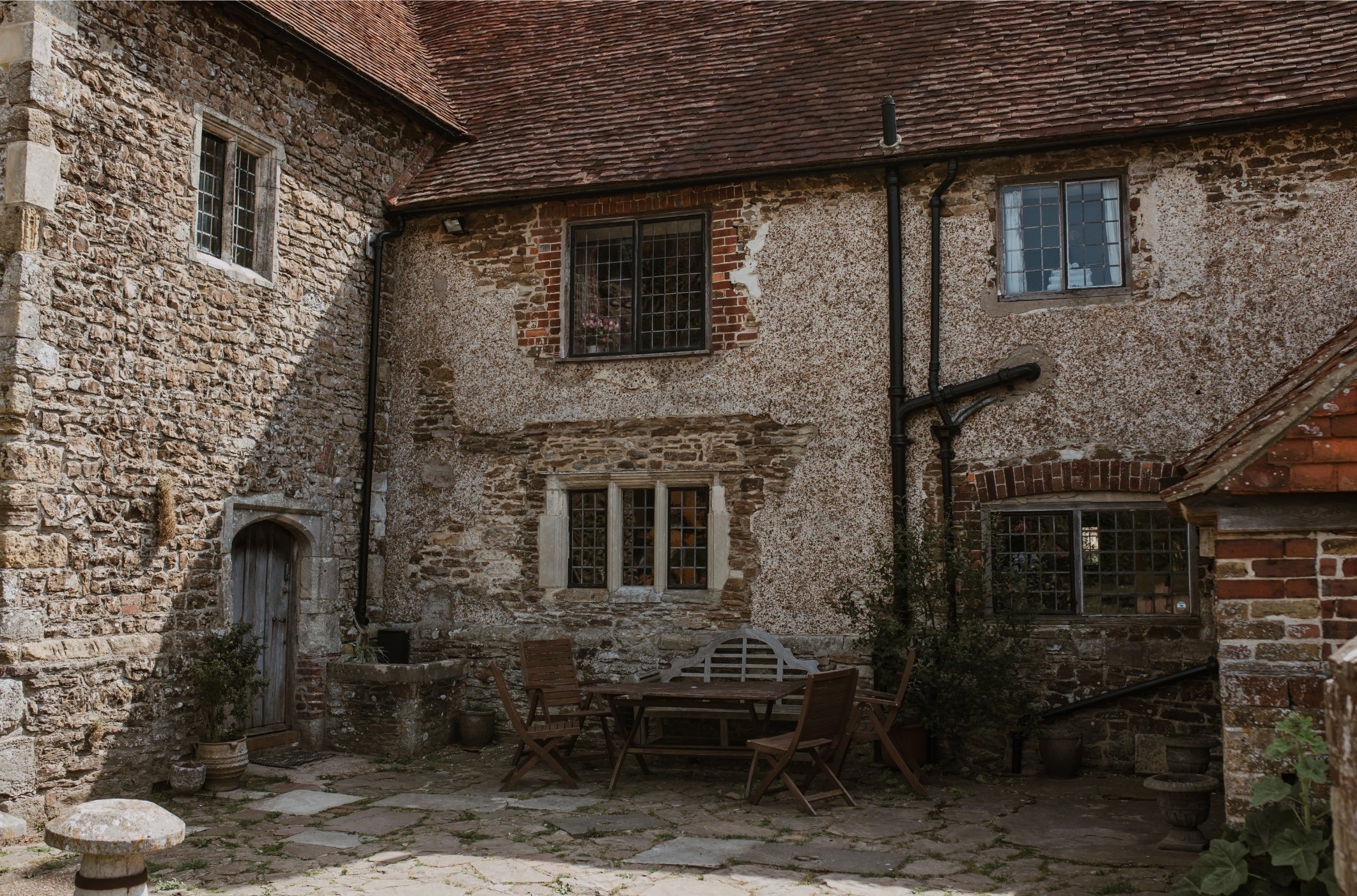 Stone building with windows and a staircase in an outdoor setting